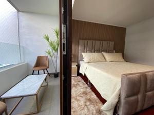 a bedroom with a bed and a chair and a window at Exclusive Apt Parque San Damin in Santiago +31 photos