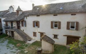 una vecchia casa bianca con una scala davanti di Gîte Enzo a Cabanès
