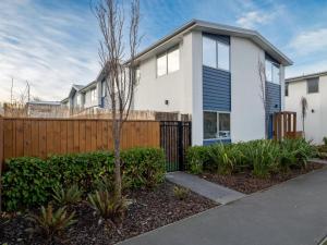 una casa blanca con una valla y arbustos en Central City Heaven Spa, en Christchurch