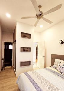 een slaapkamer met een bed en een plafondventilator bij Comfy Abode at transport hub, TBS in Kuala Lumpur