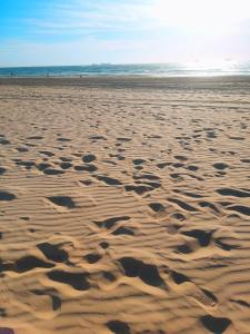 uma praia arenosa com pegadas na areia em studio by the sea em Ashdod