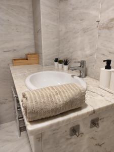 a bathroom with a sink with a towel on it at Apartamento Pedra Pateira in Ribeira