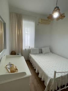 a white bedroom with a bed and a window at Myrtoan Sea View Apartment in Velanídhia