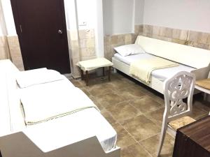 Cette chambre comprend deux lits, une table et une chaise. dans l'établissement Room in Apartment - Beautiful Holiday Home In Resort Centre, à Sidé