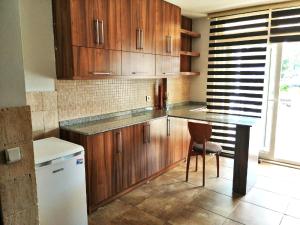 a kitchen with wooden cabinets and a table and a chair at Room in Apartment - Beautiful Holiday Home In Resort Centre in Side