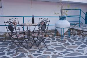 a table and chairs and a vase on a floor at Aelia Studios in Koukounaries