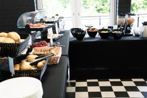 ein Buffet mit Körben voller Brot und anderen Lebensmitteln in der Unterkunft NeoHostel in Berlin + 71 Fotos