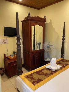 a bedroom with a bed and a mirror and a fan at Sakura Wood House in Luang Prabang