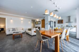 cocina y sala de estar con mesa de madera y sillas en Central 3 bedroom apartment in Sliema, onsite parking, en Sliema
