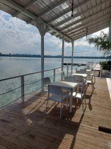 a deck with tables and chairs on the water at Hotel Florida Mamaia in Mamaia