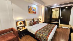 Pokój hotelowy z dużym łóżkiem i kanapą w obiekcie The Prime Balaji Deluxe @ New Delhi Railway Station w Nowym Delhi
