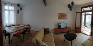 a living room with a table and a couch and a television at Villa Monette -Le Crotoy in Le Crotoy