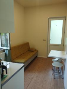 ein kleines Wohnzimmer mit einem Sofa und einem Tisch in der Unterkunft Guest House Bolnisi - Green Apartment in Bolnisi