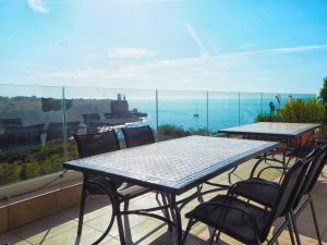 una mesa y sillas en un balcón con vistas al océano en Hotel Rocamar, en Cala Figuera