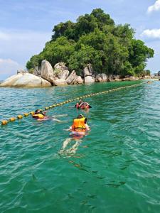 a group of people in the water near an island at L23 ,88 Resort Villa House in Pangkor