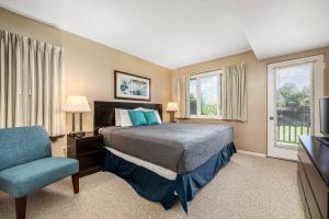 a bedroom with a bed and a chair and a television at Beautiful 2BDR Loft Suite at Golf Course Condo 5549 in Traverse City