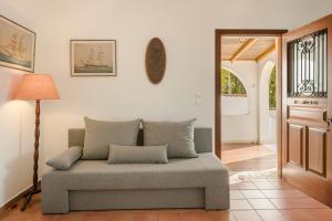 a living room with a couch and a lamp at Villa Noi- Noi The Apartment in Andipáta Erísou