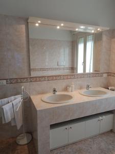 La salle de bains est pourvue de 2 lavabos et d'un grand miroir. dans l'établissement B&B Il Paiolo, à Desenzano del Garda