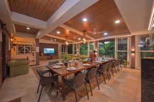 a large dining room with a long table and chairs at Bricstone House 11BHK By Stayscape Villas in Lonavala