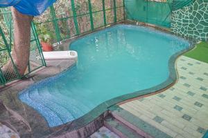 a swimming pool with a fence around it at Bricstone House 11BHK By Stayscape Villas in Lonavala