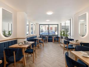 a restaurant with wooden tables and chairs and windows at Miss Marrone City Hotel in Chania