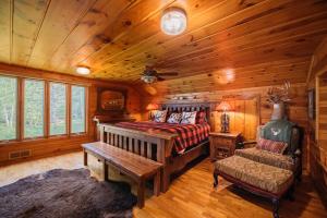 een slaapkamer met een bed en een bank in een hut bij Grayling Gem Royal Stag Serene 6BDR Lodge 5605 in Grayling