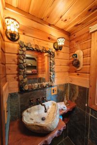 een badkamer met een stenen wastafel in een blokhut bij Grayling Gem Royal Stag Serene 6BDR Lodge 5605 in Grayling
