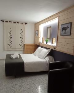 1 dormitorio con 1 cama y 1 silla en Casa Rural Felip, en Espot