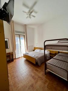 1 dormitorio con 2 camas y ventilador de techo en VILLA DEI FIORI, en Bellaria-Igea Marina