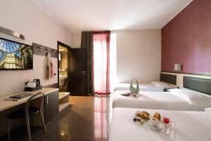 una camera d'albergo con due letti e un tavolo con un vassoio di cibo di Hotel Five a Milano