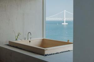 a bath tub with a view of the golden gate bridge at Onyouji Stay in Busan