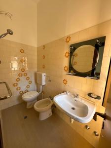 y baño con lavabo, aseo y espejo. en VILLA DEI FIORI, en Bellaria-Igea Marina