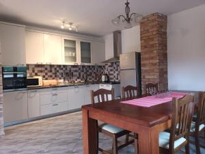 a kitchen with a wooden table with chairs and a refrigerator at Villa Katarina in Tivat