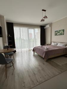 1 dormitorio con 1 cama grande y 1 mesa en Orange Batumi Travel en Batumi