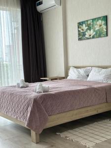 sypialnia z łóżkiem z fioletowym kocem w obiekcie Orange Batumi Travel w mieście Batumi
