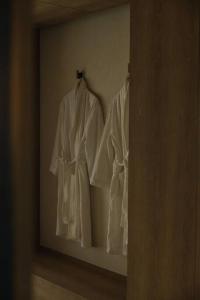 two white robes are hanging on a wall at Onyouji Stay in Busan