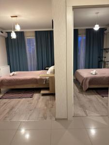 2 camas en un dormitorio con cortinas azules en Orange Batumi Travel en Batumi