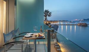 a table on a balcony with a view of the water at Kos Aktis Art Hotel in Kos Town