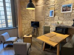 a living room with a table with a laptop on it at Le STUDIO DUO CITE MEDIEVAL SARLAT in Sarlat-la-Canéda