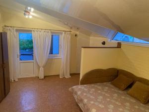1 dormitorio con 1 cama y 2 ventanas en Котедж біля моря, en Odessa