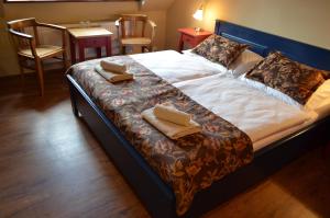 a large bed with two pillows on top of it at Penzion U Pešíků in Červený Kostelec