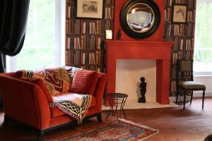 a living room with a couch and a fireplace at Le Coteau du Seigneur in Laize-la-Ville