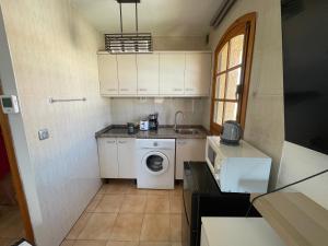 a small kitchen with a washing machine and a sink at Studio Cielo- pool, wi-fi & more in Los Urrutias