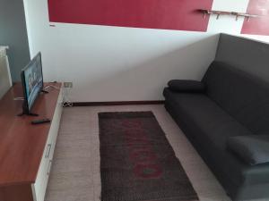 a living room with a black couch and a rug at Stay well in Orvieto Scalo
