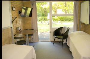 um quarto com 2 camas, uma mesa e uma janela em Danhostel Horsens em Horsens