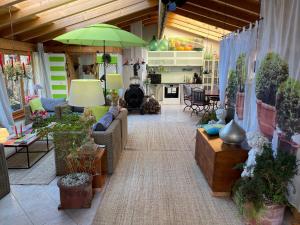 a living room filled with furniture and a green umbrella at Studioatelier am Naturschutzgebiet in Dietramszell