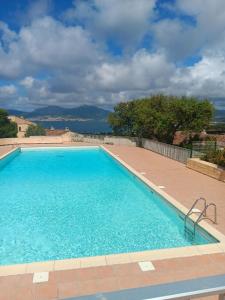 ein großes Schwimmbecken mit blauem Wasser in der Unterkunft Appartement cosy à Grosseto-Prugna - Vue sur la mer, 42 m² in Grosseto-Prugna