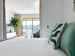 Schlafzimmer mit einem Bett mit grünen und weißen Kissen in der Unterkunft BALCÓN AL MEDITERRÁNEO Y SKYLINE DE BENIDORM in Benidorm + 47 Fotos