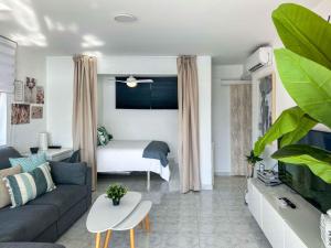 ein Wohnzimmer mit Sofa und Bett in der Unterkunft BALCÓN AL MEDITERRÁNEO Y SKYLINE DE BENIDORM in Benidorm