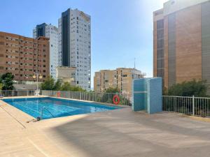 ein Schwimmbad in einer Stadt mit hohen Gebäuden in der Unterkunft BALCÓN AL MEDITERRÁNEO Y SKYLINE DE BENIDORM in Benidorm